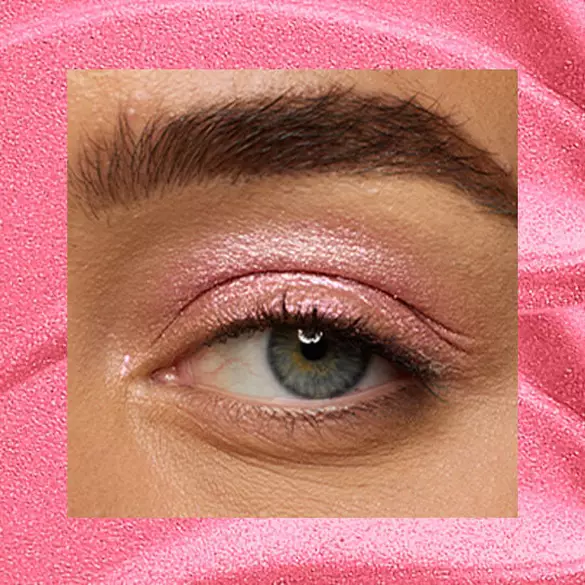 Close-up of an eye area with NYX Professional Makeup Lid Lingerie Cream Eye Pigment in 08 Push Up Pink, shown on a duochrome pink textured background.
