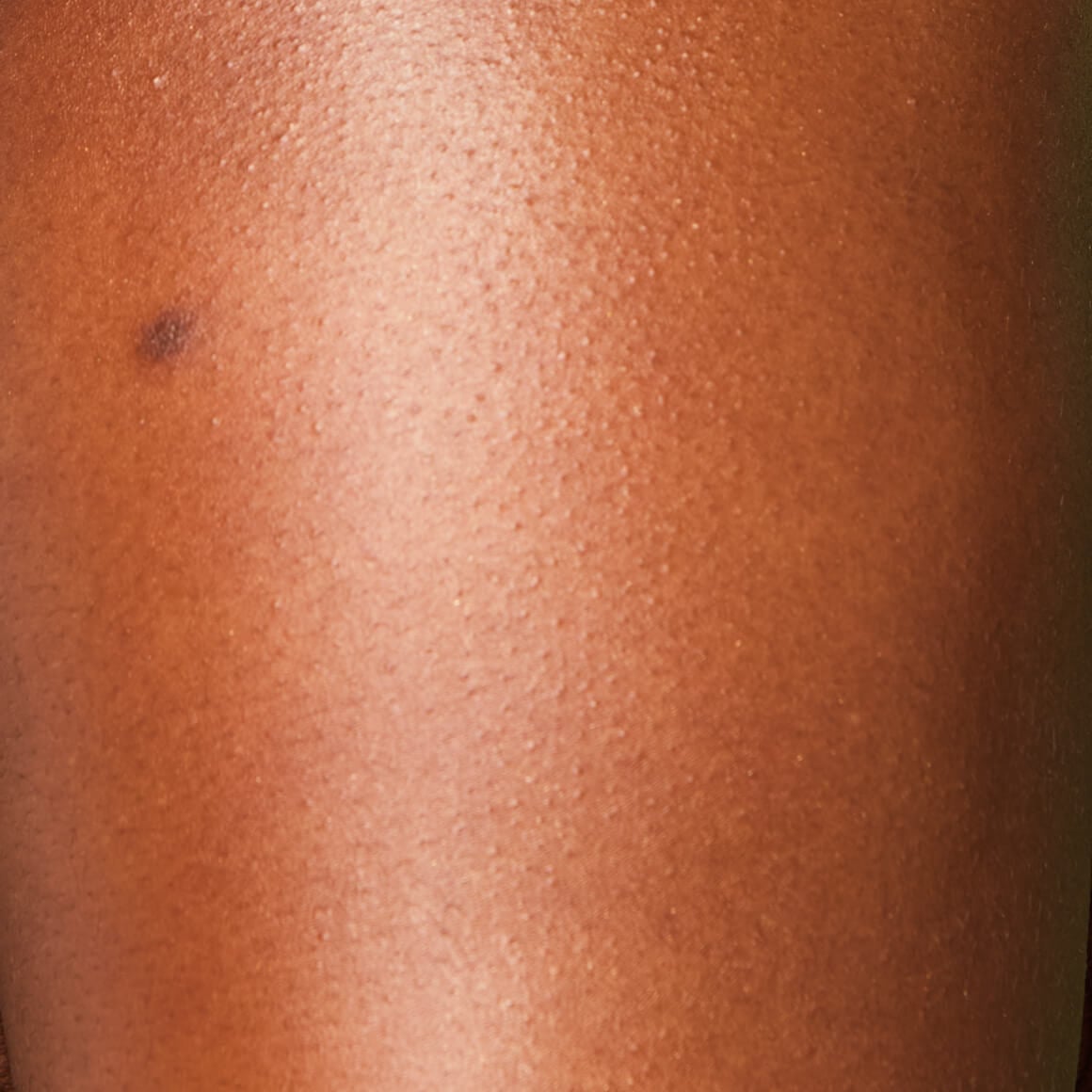 Image of the model’s arm after applying NYX Professional Makeup Caramelt Mami Body Butter giving a golden, glowy finish.